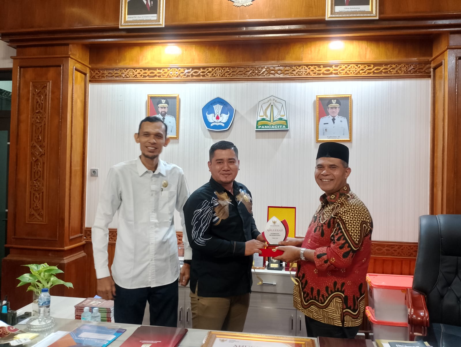 Plt Kepala Dinas Pendidikan Aceh, Murthalamuddin, S.Pd., MSP, menerimam  Penghargaan berupa sertifikat dan plakat diserahkan langsung oleh Ketua Komisi Informasi Aceh, Junaidi, dalam kunjungannya ke Dinas Pendidikan Aceh yang turut didampingi oleh Wakil Ketua Sabri, Anggota M. Nasir dan Vicky Bastianda.