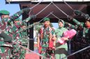 Letkol Inf Raden Herman Sasmita bersama Ketua Persit Kartika Chandra Kirana Cabang XXII Kodim 0106/Aceh Tengah, Ny. Gustin Raden Herman Sasmita, melintasi gerbang kehormatan Pedang Pora saat prosesi pelepasan di Makodim 0106/Aceh Tengah, diiringi penghormatan prajurit, Kamis (23/7/2026).(Dok:Ist)