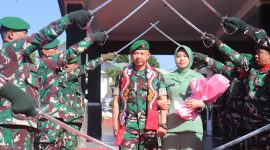 Letkol Inf Raden Herman Sasmita bersama Ketua Persit Kartika Chandra Kirana Cabang XXII Kodim 0106/Aceh Tengah, Ny. Gustin Raden Herman Sasmita, melintasi gerbang kehormatan Pedang Pora saat prosesi pelepasan di Makodim 0106/Aceh Tengah, diiringi penghormatan prajurit, Kamis (23/7/2026).(Dok:Ist)