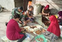 Koramil 09/Ketol Kodim 0106/Aceh Tengah Sertu Subeno membantu warga mengupas buah pinang, Sabtu (25/7/2026).(Dok: Ist)