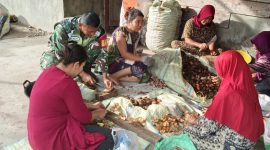 Koramil 09/Ketol Kodim 0106/Aceh Tengah Sertu Subeno membantu warga mengupas buah pinang, Sabtu (25/7/2026).(Dok: Ist)