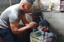 Aipda Candra Sugara, SH saat memangkas rambut pasien penderita gangguan saraf, Minggu (26/7/2026), di wilayah Kecamatan Bandar.(Dok: Rahmat Ramadhan)