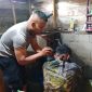 Aipda Candra Sugara, SH saat memangkas rambut pasien penderita gangguan saraf, Minggu (26/7/2026), di wilayah Kecamatan Bandar.(Dok: Rahmat Ramadhan)