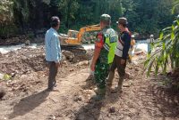 Serda Riswandi, Babinsa Koramil 08/Silih Nara, saat memantau kegiatan normalisasi aliran sungai di Desa Burni Bius Baru, Senin (26/07/2026).(Dok:Ist)