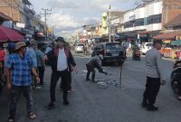 Personel Polsek Bandar mengatur arus lalu lintas saat kegiatan penambalan jalan berlubang yang dilakukan Komunitas Kaliber Pondok Baru bersama warga di Kecamatan Bandar,Senin (27/7/2026).(Dok:Ist)