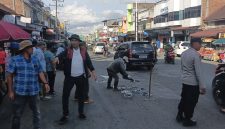 Personel Polsek Bandar mengatur arus lalu lintas saat kegiatan penambalan jalan berlubang yang dilakukan Komunitas Kaliber Pondok Baru bersama warga di Kecamatan Bandar,Senin (27/7/2026).(Dok:Ist)