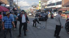 Personel Polsek Bandar mengatur arus lalu lintas saat kegiatan penambalan jalan berlubang yang dilakukan Komunitas Kaliber Pondok Baru bersama warga di Kecamatan Bandar,Senin (27/7/2026).(Dok:Ist)