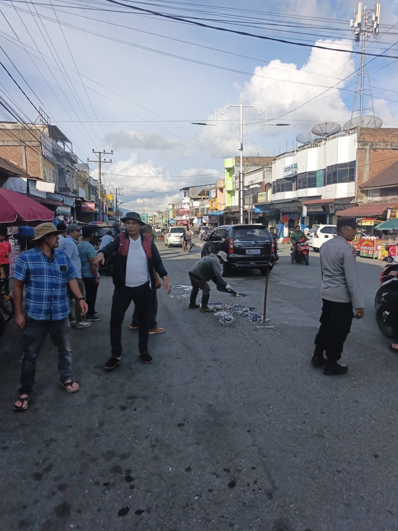 Personel Polsek Bandar mengatur arus lalu lintas saat kegiatan penambalan jalan berlubang yang dilakukan Komunitas Kaliber Pondok Baru bersama warga di Kecamatan Bandar,Senin (27/7/2026).(Dok:Ist)